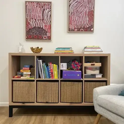 A cozy living room featuring a couch, an armchair, and a bookshelf filled with books.